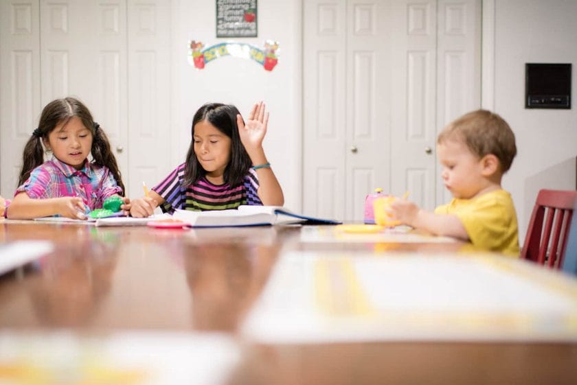 An image of 3 kids homeschooling.