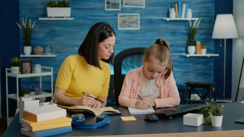 An image of a Young child doing homework with her mother for remote education.