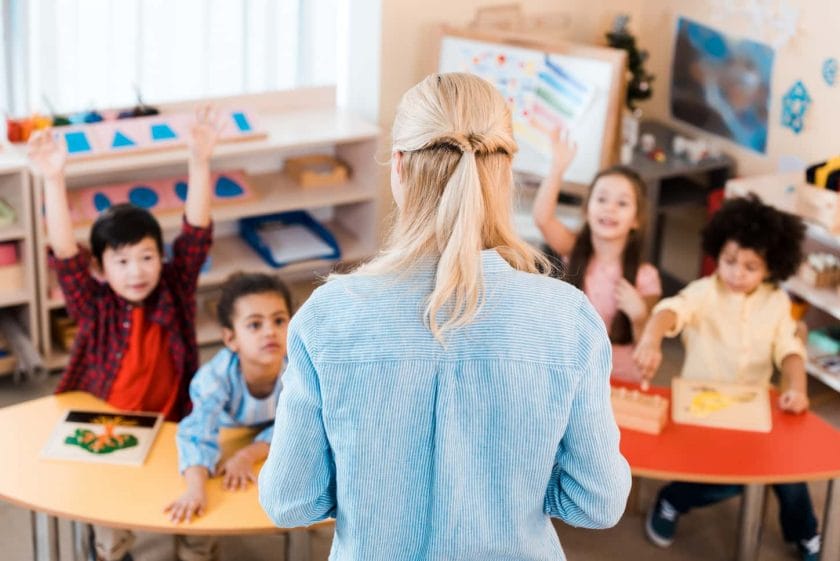 An image of Selective focus of teacher conducting lesson with kids in Montessori school.