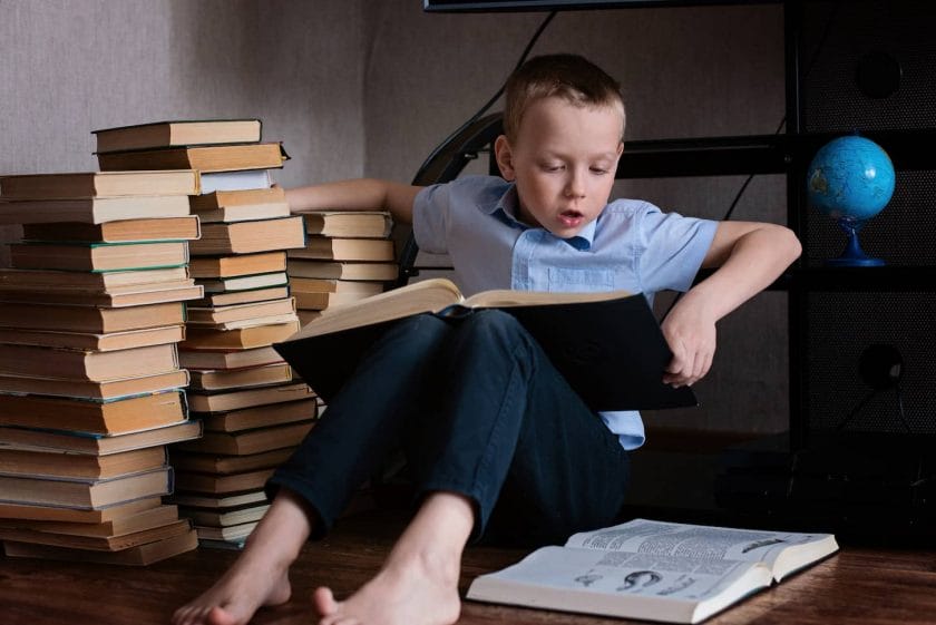 An image of a seven-year-old boy reading book, a child is enthusiastically reading a book.