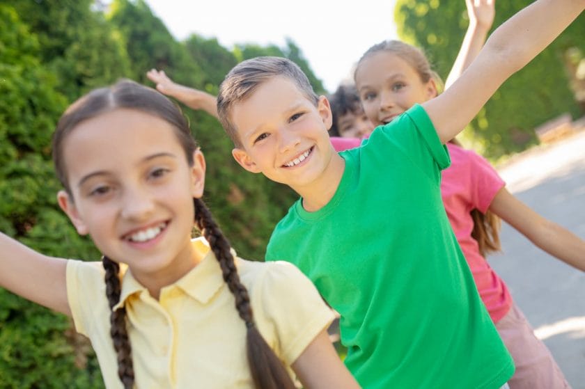 An image of Smiling kids actively playing in the park.