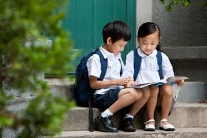 An image of Two Chinese school children studying outside.