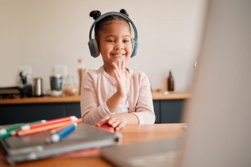 An image of Distance learning, education, and a virtual student child on a video call lesson with a headset and laptop in front of her.