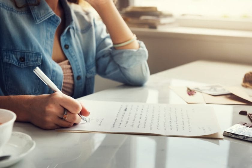 An image of a woman writing a letter.