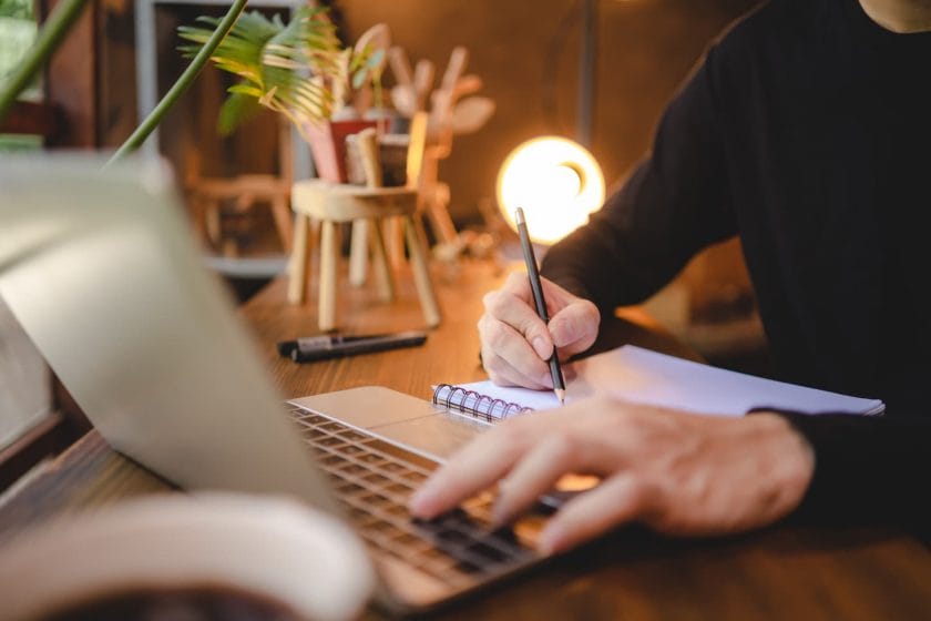 An image of people's hands holding a pen for working to write on a book for a letter or business document.